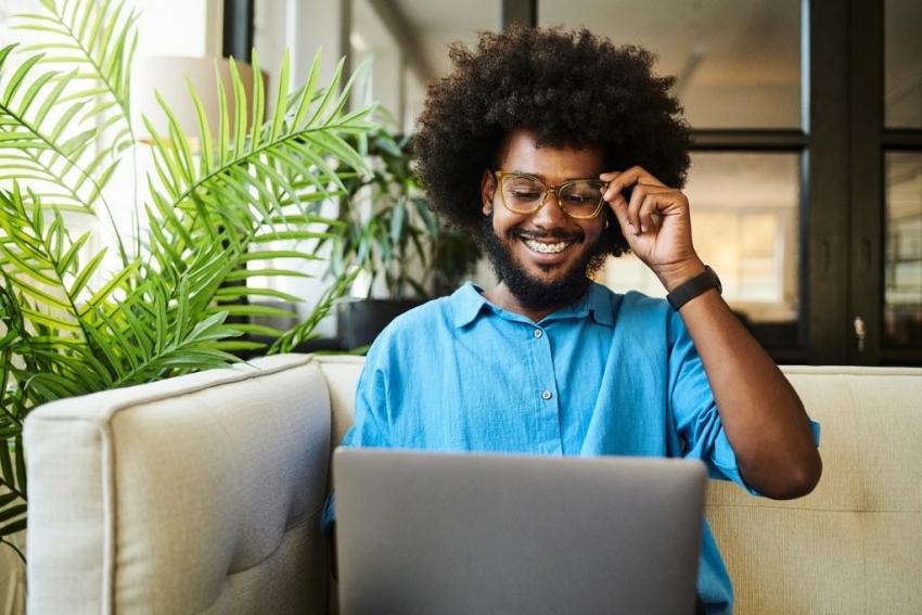 Banner image of man sitting on sofa with laptop