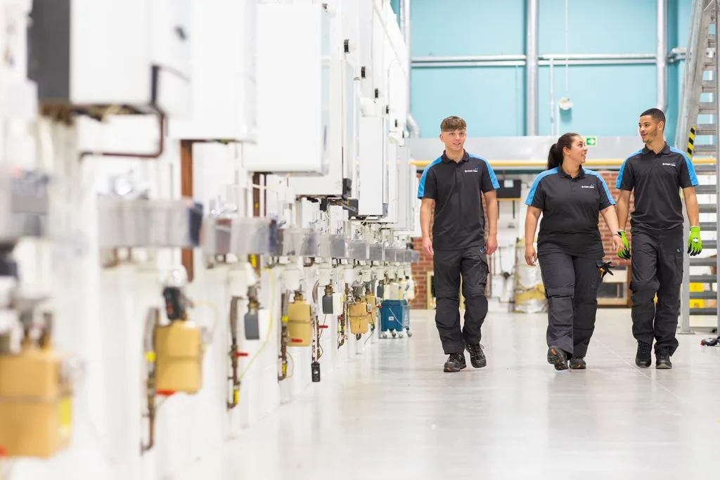 Engineers walking down a room British gas uses to teach them how to fix boilers