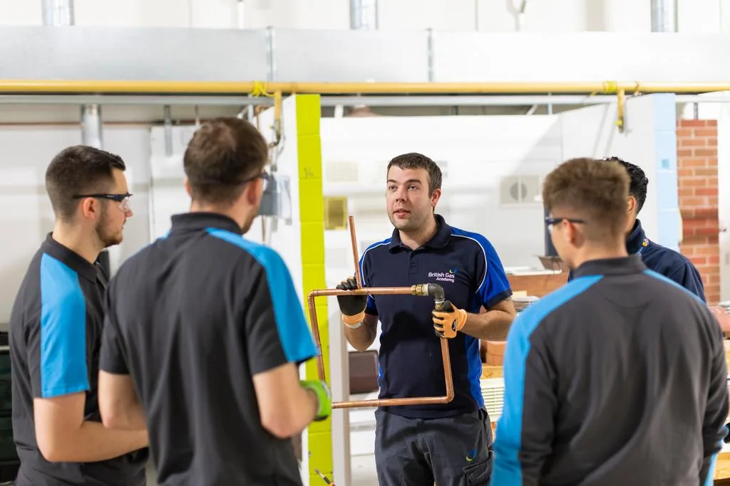 Engineer teaching other engineers around pipes